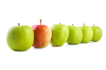 Red apple in a row of green apples