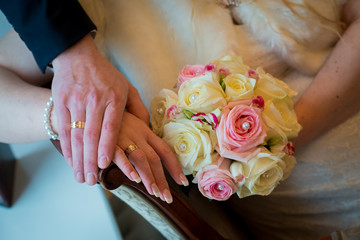 Hands and rings with beautiful wedding bouquet