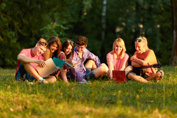 Fototapeta premium group of happy students with books in the Park on a Sunny day