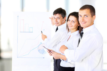 A senior business executive delivering a presentation to his colleagues during a meeting or in-house business training