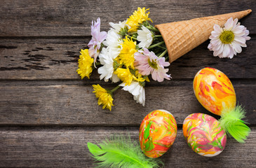 Easter background with eggs, flowers, and decoration on wooden b