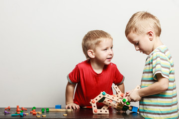 Children play with toy on table.
