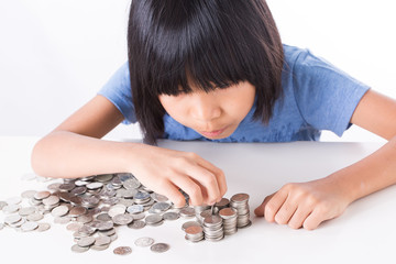 Cute Little asian girl and pile coin for saving. money concept  in thinking action with white background