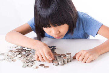 Cute Little asian girl and pile coin for saving. money concept  in thinking action with white background