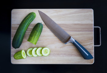 cucumber cut segment on board with knife