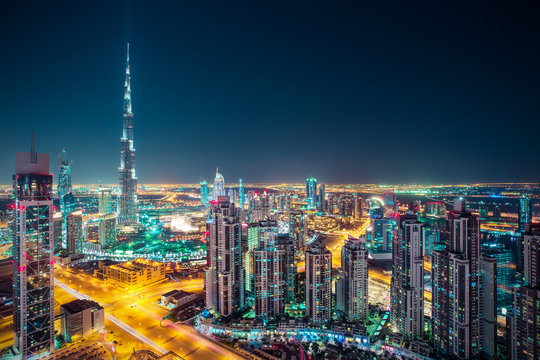 Fantastic nighttime Dubai skyline with illuminated skyscrapers. Rooftop perspective of downtown Dubai, UAE. © Funny Studio