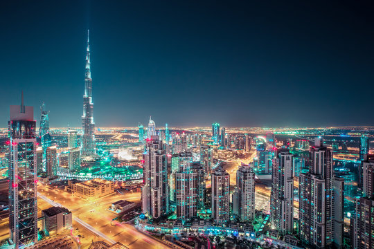Fantastic nighttime Dubai skyline with illuminated skyscrapers. Rooftop perspective of downtown Dubai, UAE.