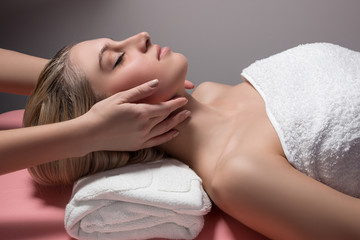 Obraz na płótnie Canvas beautiful woman receiving facial massage
