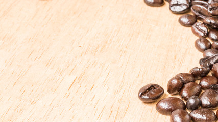 Brown roasted coffee beans on wooden background