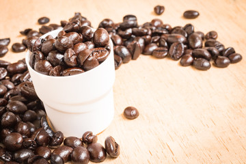 Brown roasted coffee beans on wooden background