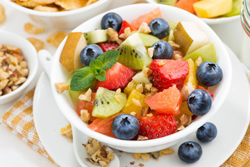 breakfast with fruit salad and corn flakes, closeup top view