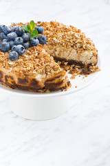 cheese pie with oat flakes on a stand, vertical