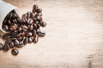 Brown roasted coffee beans on wooden background