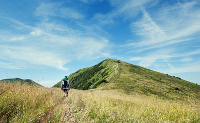 Fototapeta premium Alone hiker walking by the mountain path