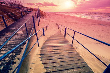 Stairway to the sandy beach at sunset