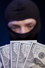 Man in black mask holding the money