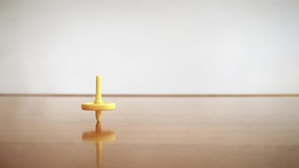 yellow spinning top toy at the wooden table