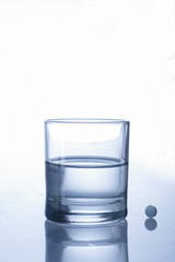 Bicchiere d'acqua con pillole