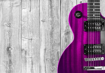 Part of the pink electric guitar on wooden background. A place for writing of the text.
