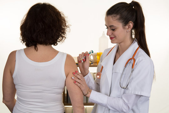 Doctor female gives an intramuscular injection in female arm