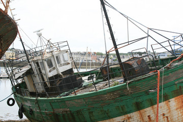 Fototapeta na wymiar Old and rusty desolate fishing ship in harbour