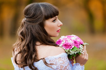 Naklejka premium brunette bride autumn background with bouquet