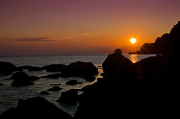 Rocks  silhouettes and sunset sea. Minimalizm