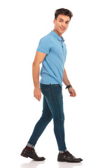 side portrait of young man in blue shirt walking