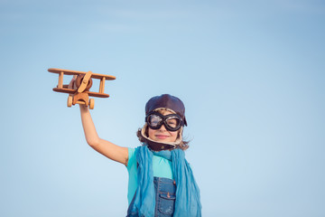 Happy kid playing with wooden toy airplane