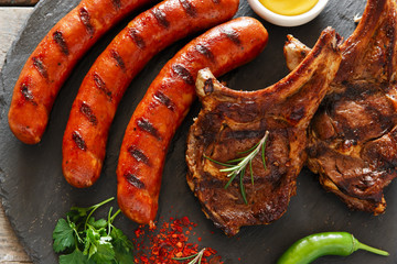 Grilled sausages and steak on the bone barbecue