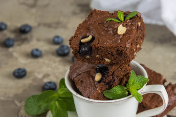 Chocolate brownie with peanuts,blueberries and mint in a white Cup