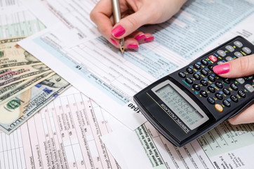 business woman holding pen and calculator on Tax  Form 1040