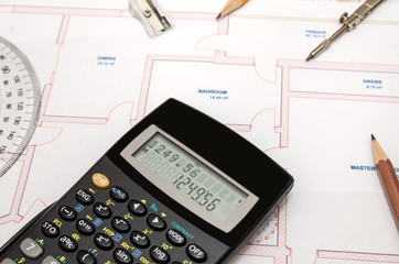 Architect's workspace with plan and pencil, calculator, ruler, compass