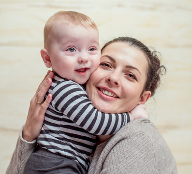 Attractive young mother hugging her little baby