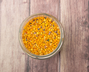 Bee pollen in a mason jar over wooden background