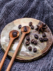 Coffee beans and star anise in ceramic plate with wooden spoons