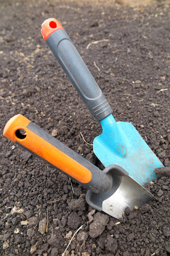 Garden scoops in the loosen soil in the garden