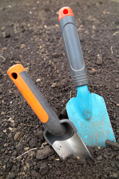 Garden scoops in the loosen soil in the garden