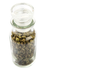 Green peppercorn in glass vial over white background