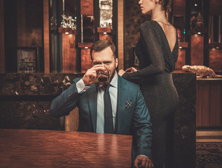 Well-dressed couple in luxury apartment interior.