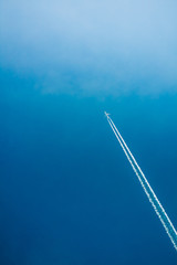 Airplane In Sky With Plane Trails