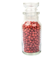 Pink peppercorns in vial glass over white background
