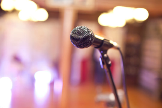 Close-up of a microphone in a concert hall on the background of blurred lights