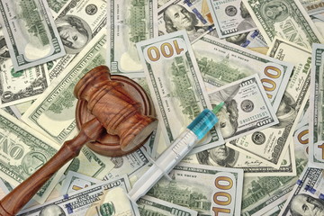 Judges Gavel And Syringe With Injection On Dollar Cash Backgroun