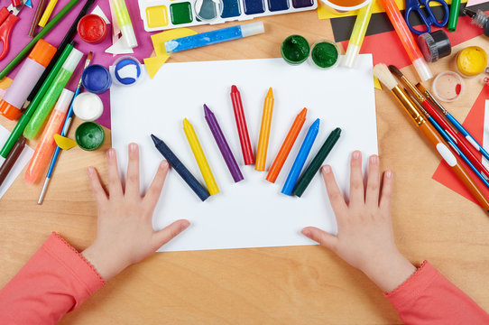 Child drawing top view. Artwork workplace with creative accessories. Flat lay art tools for painting.
