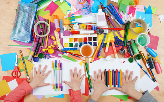Child drawing top view. Artwork workplace with creative accessories. Flat lay art tools for painting.