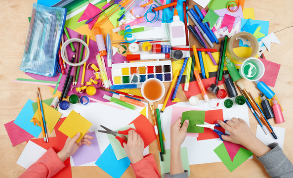 Child drawing top view. Artwork workplace with creative accessories. Flat lay art tools for painting.