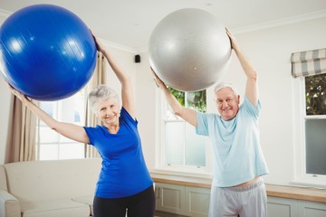 Senior couple exercising with exercise ball