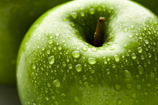 apple in green with water drops on its surface