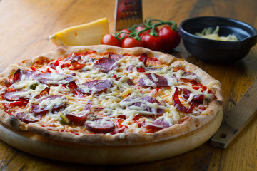 Delicious pizza with salami, tomatoes